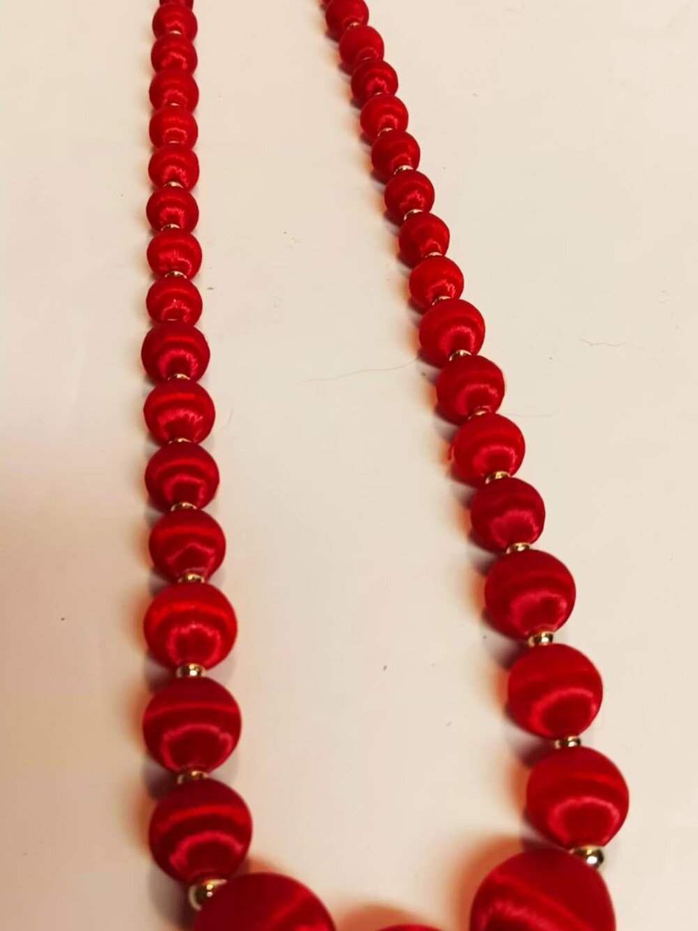 Necklace, ruby red silk/satin covered beads, 3/8 to 3/4" & goldtone spacers.